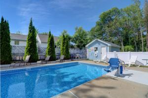 a swimming pool with chairs and a house at Brookside Inn & Cottages in Saco