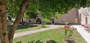 un jardin avec un arbre et un bâtiment dans l'établissement Domaine de Gaïa, Piscine, Pétanque, Ping-pong, proche Saint Emilion, à Guillac