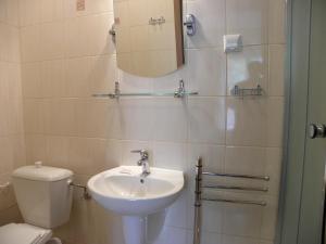 a bathroom with a sink and a toilet and a mirror at Villa AS in Świnoujście