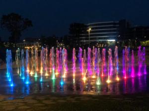 a water fountain at night with colorful lights at Sun & Love Apartment in Koper +10 photos
