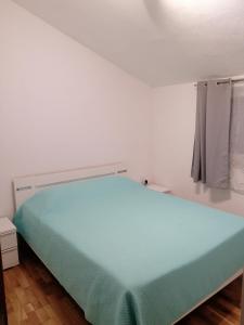 um quarto com uma cama azul num quarto em Apartments Davor em Postira