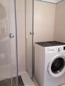 a washing machine in a bathroom with a shower at Blu Home in Crotone