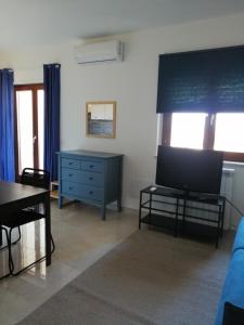 ein Wohnzimmer mit einem TV und einer blauen Kommode in der Unterkunft Blu Home in Crotone