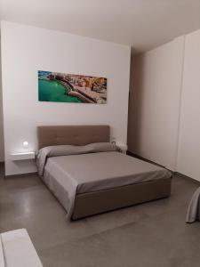 a bedroom with a bed and a painting on the wall at Dimora Felline in Giurdignano