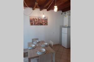 een eetkamer met een tafel en een keuken met een schilderij bij Casa vacanza Jacopo in Bergamo