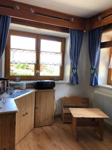 a kitchen with wooden cabinets and a table and two windows at Zugspitzhaus Monika in Lermoos