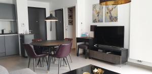 a kitchen and living room with a table and a television at Les Campanules in Bourg-Saint-Maurice