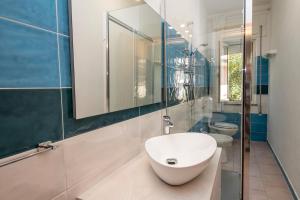 a bathroom with a white sink and a toilet at A.I.R. Hotel Gabbiano in Isola Rossa