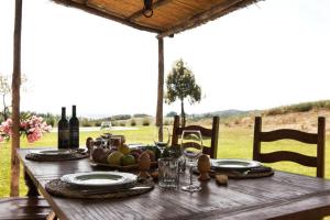 una mesa de madera con comida y copas de vino. en Sant'Ilaria - private 2 bdrs pool villa, en Villa Montesoli