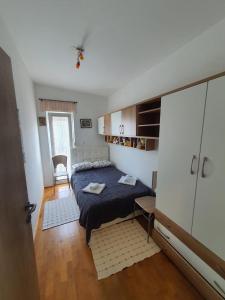 a small bedroom with a bed and a cabinet at Apartment Sara in Umag
