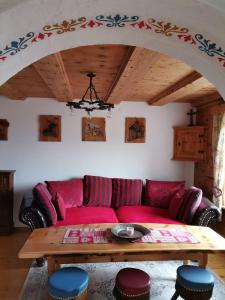 a living room with a red couch and a wooden table at Märchenschlössel Altenstein in Trebesing