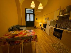 cocina y sala de estar con mesa y cocina en Casa Natalia Holiday Home, en Catania