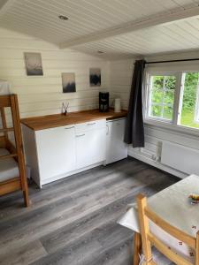 
a kitchen with a table, chairs and a refrigerator at Enderupskov Camping & Cottages in Gram
