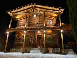 une maison en bois avec des lumières au-dessus dans l'établissement Anti Onirou, à Flasou