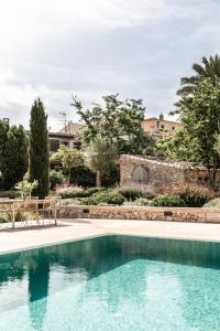 una piscina en un patio con sillas y árboles en Can Sull, en Cas Concos