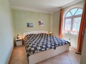 um quarto com uma cama e uma janela em Holiday house Joshi & Rudi (No. 71) em Gyenesdiás