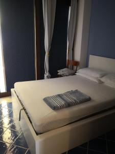 a white bed with a towel on top of it at Villino Gambino in Menfi