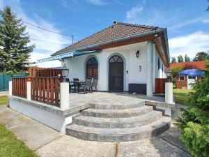 uma pequena casa branca com um pátio e escadas em Holiday house Joshi & Rudi (No. 71) em Gyenesdiás