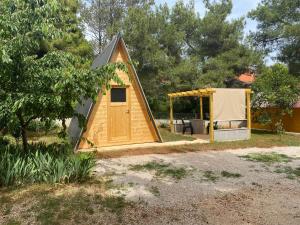 a small house with a tent in a yard at Camp Din in Novigrad Istria