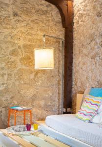a bedroom with a bed and a stone wall at Villa Rocca in Nikiana