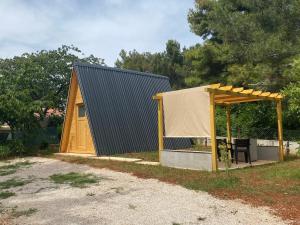 a small cabin with a roof and a tent at Camp Din in Novigrad Istria