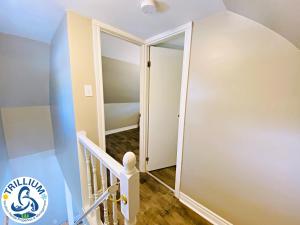 a hallway with a door leading to a stairway at The Cabana House in Wasaga Beach