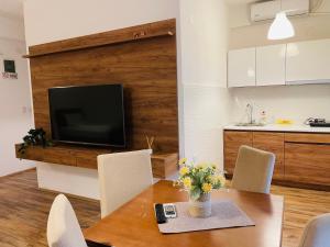 sala de estar con mesa con sillas y TV en Fuk-tak apartmani&restoran, en Star Dojran