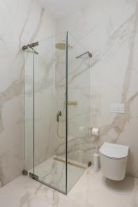 a glass shower in a bathroom with a toilet at Plaza Apartments in Opatija