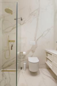 a white bathroom with a shower and a toilet at Plaza Apartments in Opatija