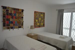 Dieses weiße Zimmer verfügt über 2 Betten und ein Fenster. in der Unterkunft MORADIA NOVA E COMPLETA A 350 MTRS. PRAIA in Vila Nova De Cacela
