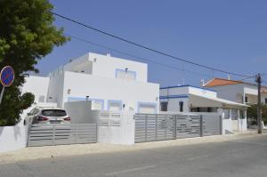 a white house with a car parked in front of it at MORADIA NOVA E COMPLETA A 350 MTRS. PRAIA in Vila Nova de Cacela