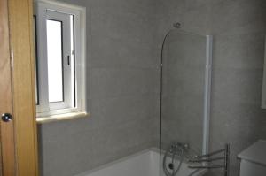 a bathroom with a shower with a tub and a window at MORADIA NOVA E COMPLETA A 350 MTRS. PRAIA in Vila Nova de Cacela +14 photos