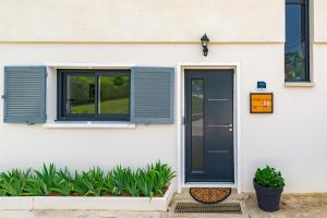 uma casa branca com uma porta azul e janelas em Au 10 le long du canal em Fain-lès-Montbard