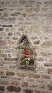 un mur en briques avec un vase avec des fleurs. dans l'établissement Non ditelo al Duca - Belvedere Sant'Angelo, à Spolète