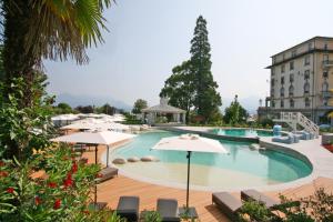 a large swimming pool with umbrellas and a building at Grand Hotel des Iles Borromées & SPA in Stresa