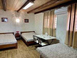 a room with two beds and a table with chairs at Alkatraz in Gribovka