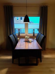 a dining room table with chairs and a large window at Ferienwohnung Am Ostfriesland-Wanderweg in Rhauderfehn