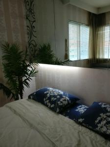 a bedroom with a bed with blue and white pillows at Luxurious 2 BR Apartment on Sudirman Rd in Central Jakarta in Jakarta