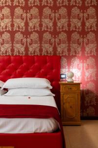 a red bed with a red headboard in a room at Relais La Torre in Verona
