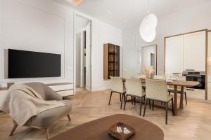 a living room with a table and chairs and a television at Plaza Apartments in Opatija
