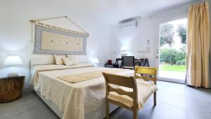 a bedroom with a bed and a chair and a window at Sole Matto Rooms in Olbia