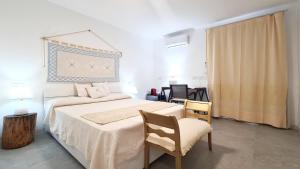 a bedroom with a large bed and a chair at Sole Matto Rooms in Olbia