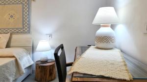 a table with a lamp sitting on top of it at Sole Matto Rooms in Olbia