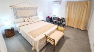 a bedroom with a bed and a chair and a desk at Sole Matto Rooms in Olbia