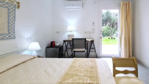 a bedroom with a bed and a table and chairs at Sole Matto Rooms in Olbia