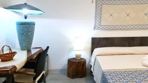 a bedroom with a bed and a desk with a lamp at Sole Matto Rooms in Olbia