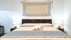 a bedroom with a bed with two towels on it at Sole Matto Rooms in Olbia