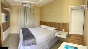 a small bedroom with a bed and a window at Pousada Life in Ubajara
