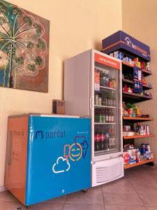 a refrigerator is next to a shelf with drinks at Vilamar Suítes in Aquiraz