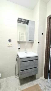un baño con lavabo y espejo en BUGAZ GOLD апартаменти біля моря, en Karolino-Buhaz 35 fotos más